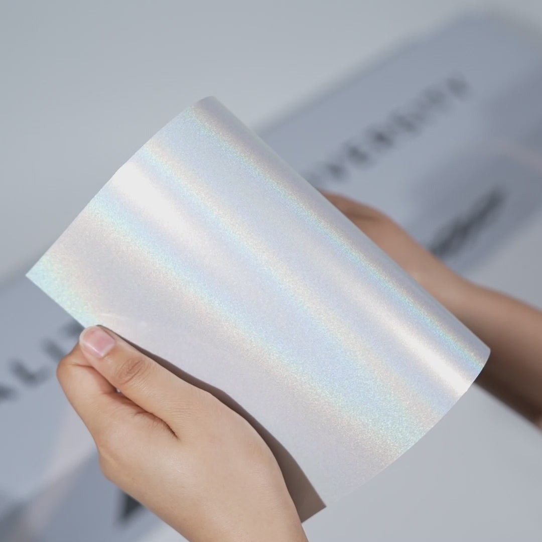 Hands holding a TeckWrap Diamond Sparkle Metallic PPF sample (CPX401), showcasing its glittery iridescent finish and premium paint protection surface.