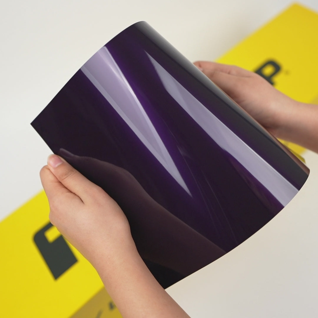 Hands holding Silent Purple (GAL34-HD) TeckWrap vinyl wrap sample with glossy finish