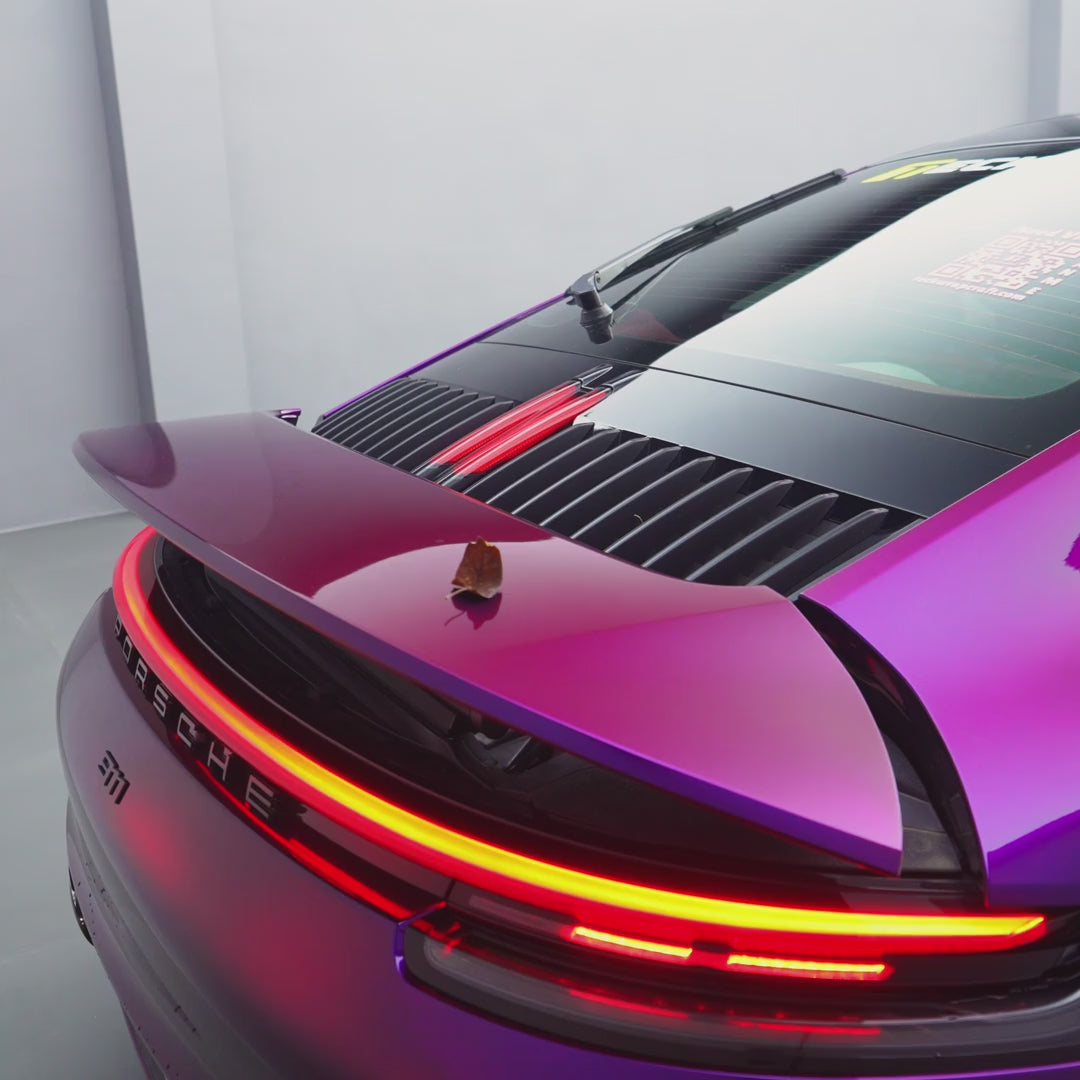 Porsche 911 with TeckWrap Deep Gloss Luxury Purple Amethyst paint protection film (CPX602), showing the color-shift purple finish in a studio