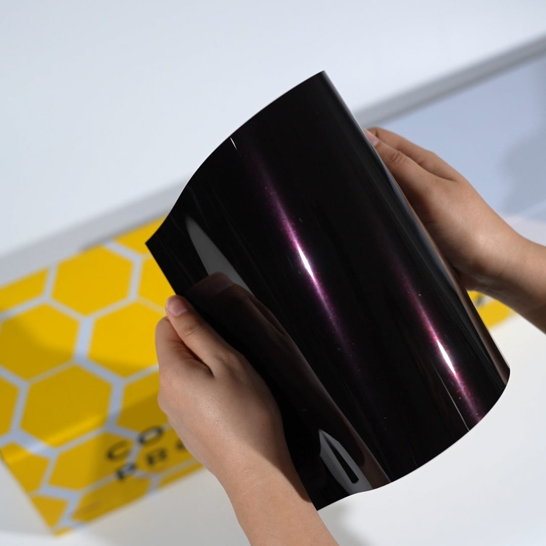 TeckWrap A5 Metallic PPF sample showing black finish with magenta purple light reflection