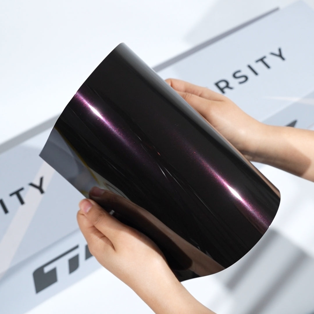 Gloss black TeckWrap A5 Pearlescent PPF sample with deep purple color shift and sharp light reflection