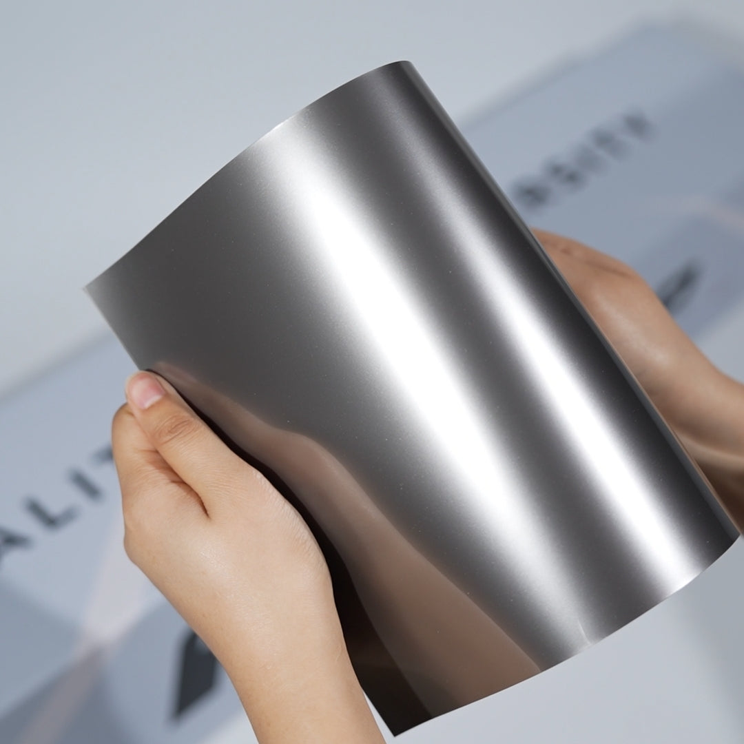 TeckWrap A5 Metallic PPF sample in gunmetal silver with strong vertical light reflection