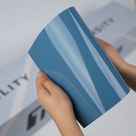 Dusty blue TeckWrap A5 Pure Color Paint Protection Film sample held in hands