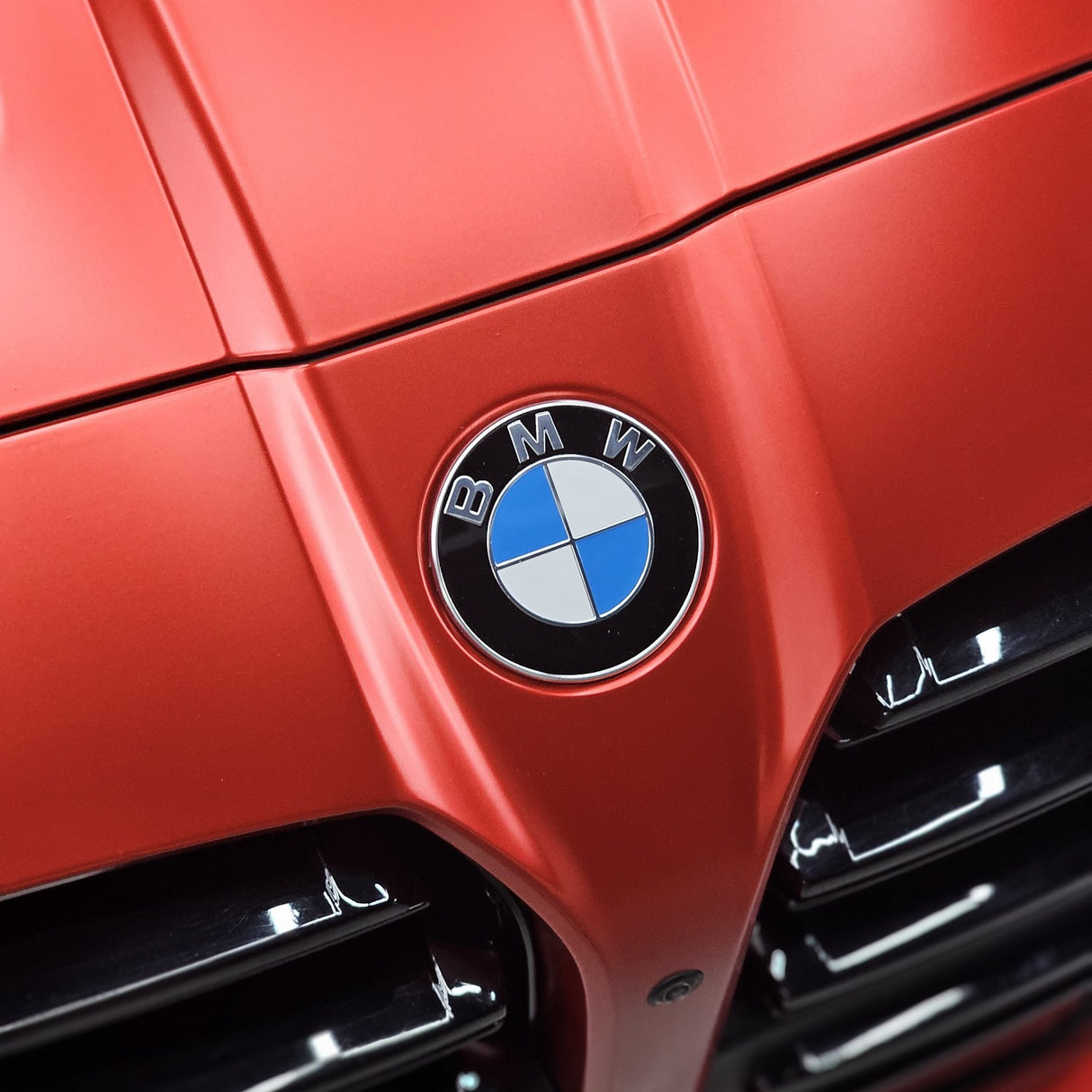TeckWrap Satin Crimson Red vinyl (VCH401-S) around the BMW roundel on the hood