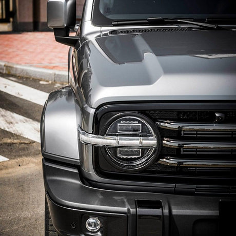 Detailed close-up of the Tank SUV’s headlight and front fender wrapped in Gloss Arctic Silver (RB27-HD), showcasing the smooth contours and reflective quality of TeckWrap’s premium gloss vinyl.