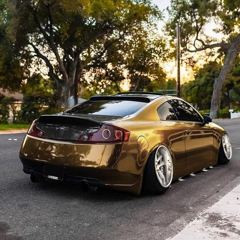 a sports car elegantly wrapped in TeckWrap Gloss Black Gold Vinyl Wrap