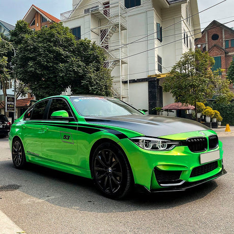 BMW sedan featuring Kelly Green (RB22-HD) vinyl wrap, complemented by sporty black graphics and detailing on an urban street.