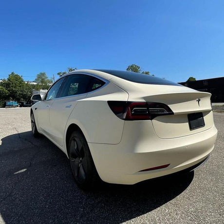 Rear side-angle view of Tesla Model 3 featuring Vanilla Cream (SCM26-R) Matte Vinyl Wrap, accentuating its sleek profile