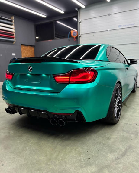 Rear close-up angle of a BMW wrapped with TeckWrap Emerald Green Satin Vinyl, highlighting the rich emerald satin surface.