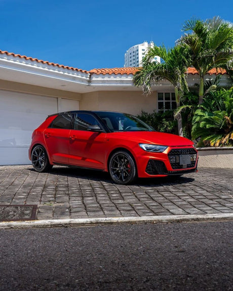Wide front angle of hatchback vehicle fully wrapped in Flame Red SMT15 satin vinyl by TeckWrap, reflecting a matte red sheen.