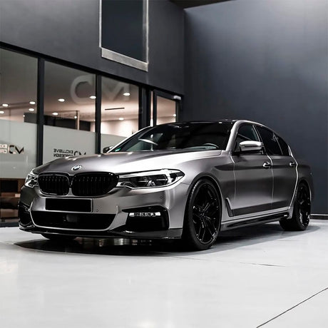 BMW sedan wrapped in TeckWrap Gunsmoke Grey (ECH02) Satin Vinyl, exhibiting a striking, modern appearance under showroom lights.